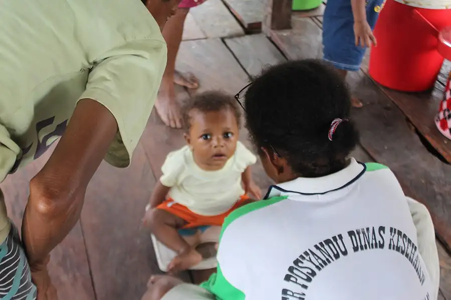 Kader memeriksa bayi di posyandu Kampung Benawa